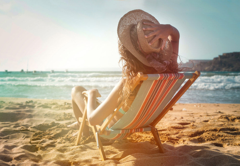 ragazza prende il sole in spiaggia